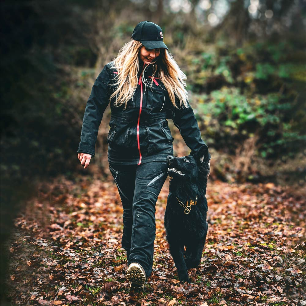 Hundeführerin mit Schäferhund in funktionaler Hundesport-Jacke im Unterordnungstraining