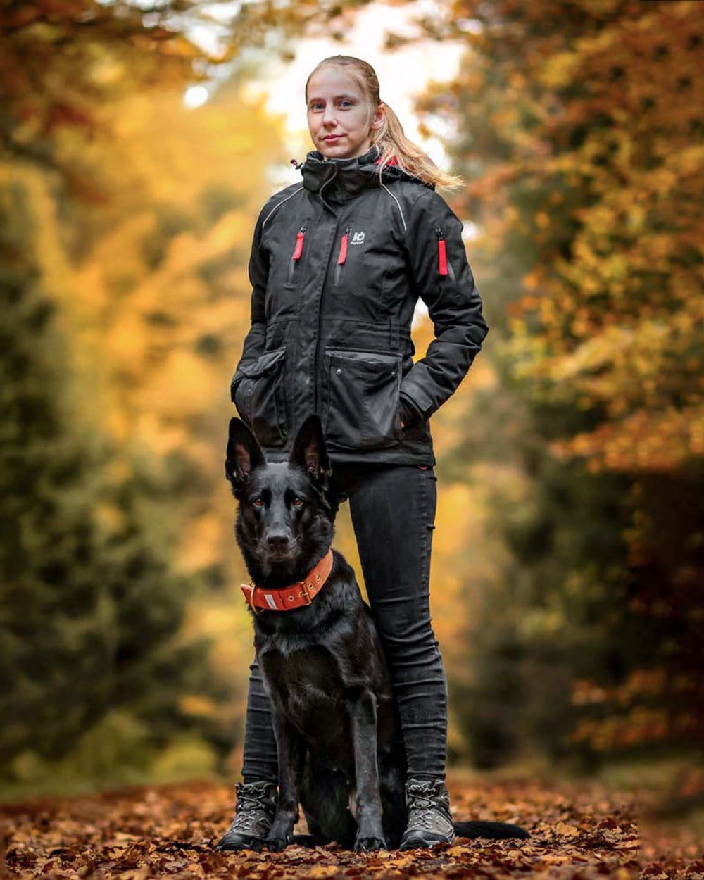 Handler wearing an IQ multifunction jacket with a German Shepherd in autumn